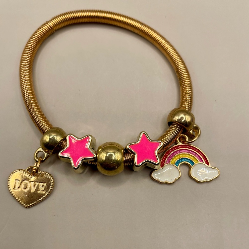 Yellow gold plated spring baby bangle with rainbow, heart and star charms.